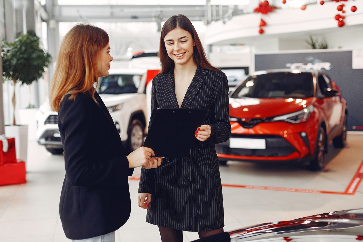A salesperson going through paperwork with a customer in a car showroom